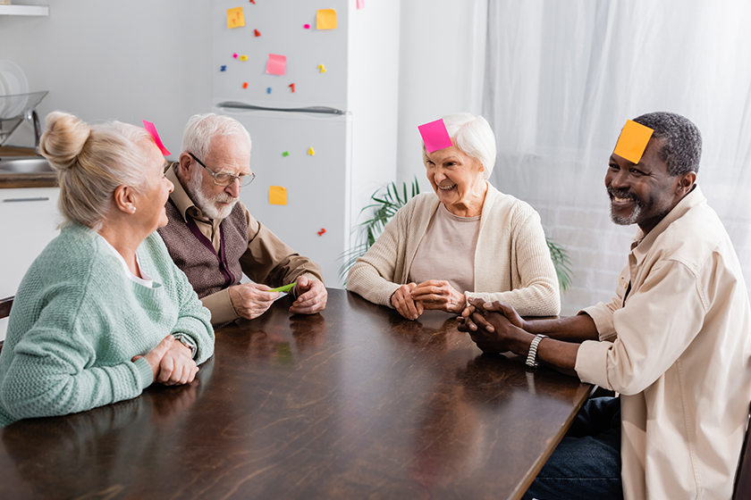 Smiling multicultural senior friends with colorful sticky notes.